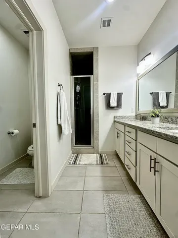 a spacious bathroom with a granite countertop sink and a mirror