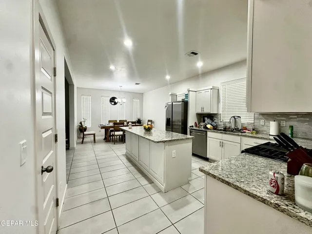 a large kitchen with granite countertop a large counter top stainless steel appliances and a sink