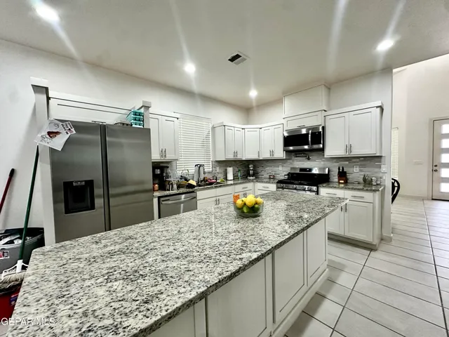 a kitchen with stainless steel appliances granite countertop a sink a stove counter space and cabinets