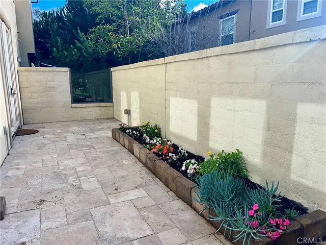 a view of a backyard with chairs and flowers