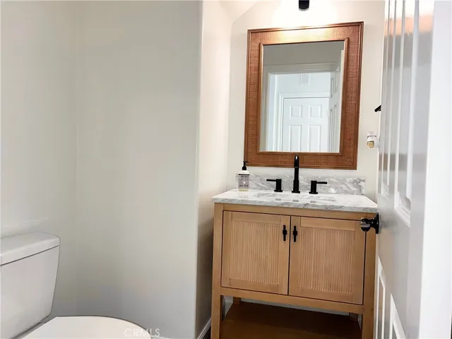 a bathroom with a sink toilet and mirror