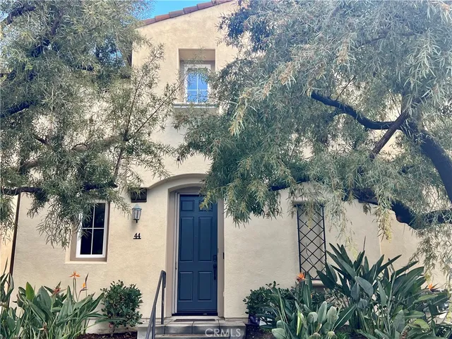 a front view of a house with a tree