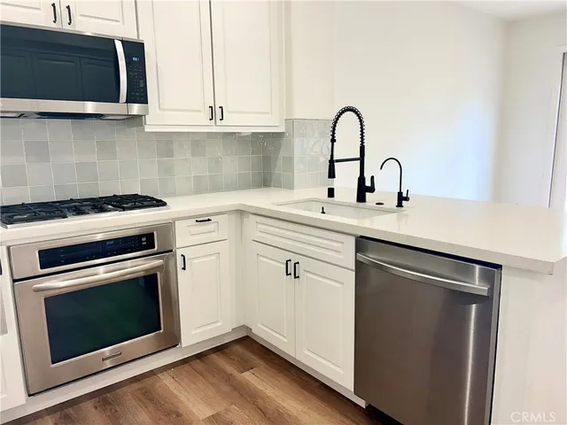 a kitchen with sink a microwave and stove