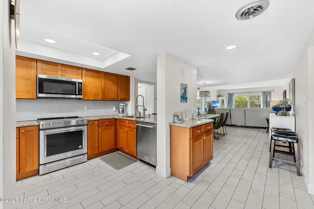 a kitchen with granite countertop a stove top oven sink and cabinets