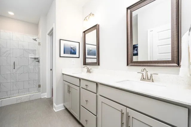 a bathroom with double sink and two mirror