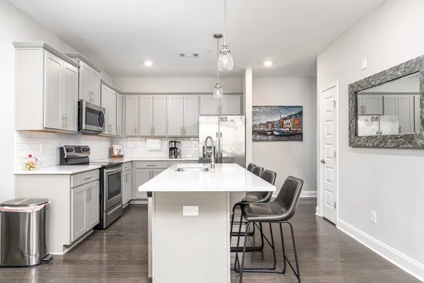 a kitchen with a table chairs microwave and cabinets