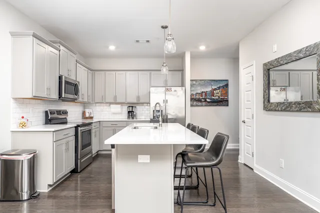 a kitchen with a table chairs microwave and cabinets