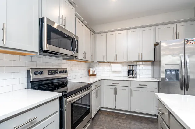 a kitchen with cabinets stainless steel appliances and sink