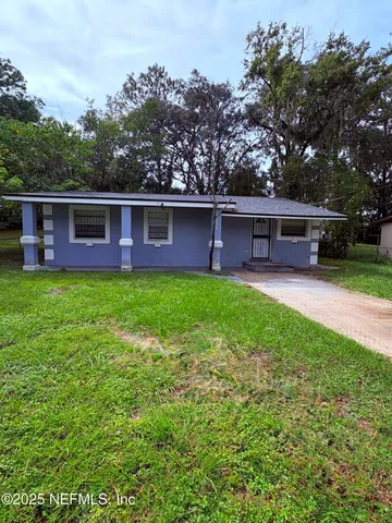front view of a house with a yard and trees