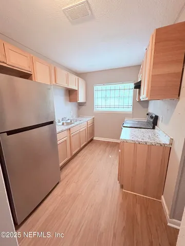 a kitchen with stainless steel appliances granite countertop a refrigerator a sink and a stove