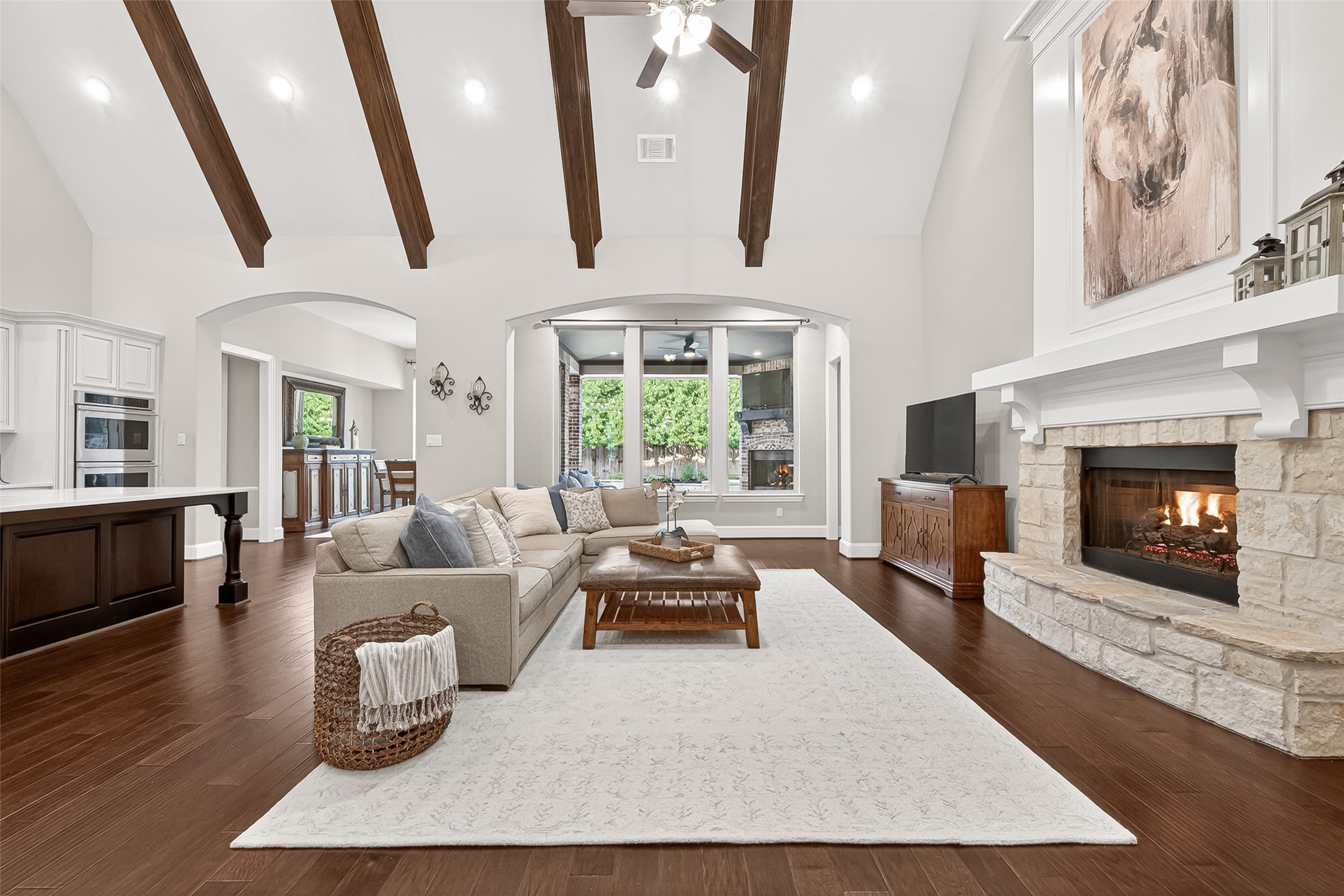 2803 Mayfield Ridge Lane Katy, TX 77494 - Photo 9 of 40 Gorgeous vaulted ceiling with wood beams, gas log stone fireplace open to the fabulous kitchen with stunning views of the backyard oasis!