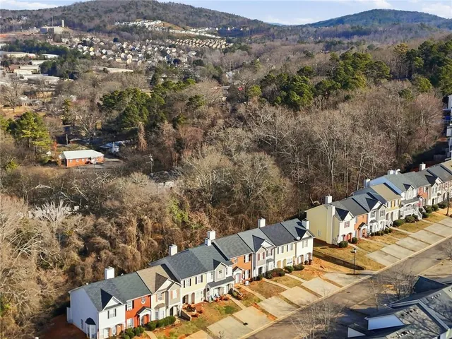 an aerial view of a house with a mountain