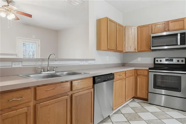 a kitchen with granite countertop a sink and stainless steel appliances