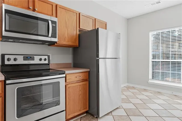 a kitchen with stainless steel appliances white cabinets and a stove top oven