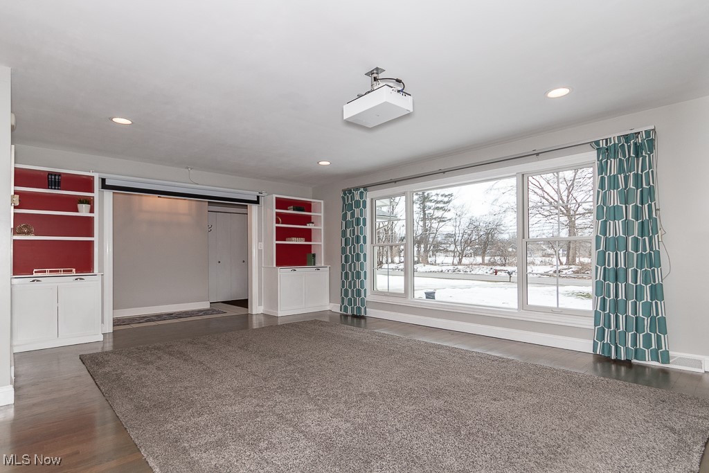 Living room featuring built-in bookshelves, hardwood floors and Pella windows