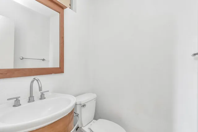 a bathroom with a sink a toilet and mirror