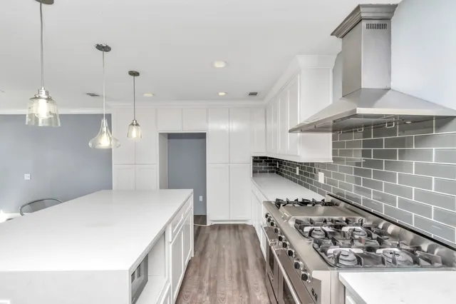 a kitchen with stainless steel appliances a stove a sink and a refrigerator