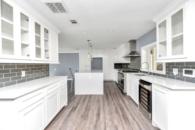 a kitchen with white cabinets and appliances