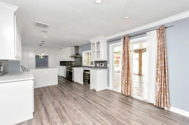 a kitchen with a refrigerator a stove top oven and white walls