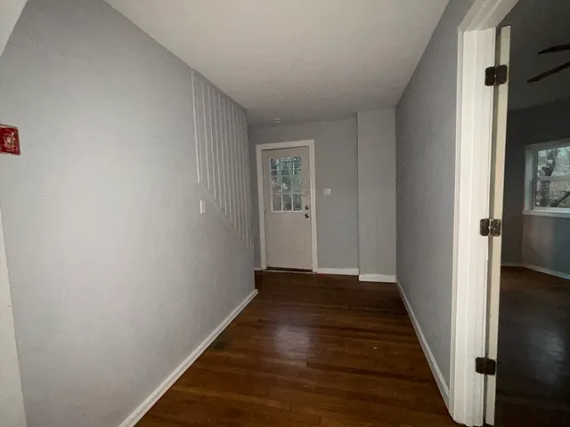 a view of a hallway with wooden floor