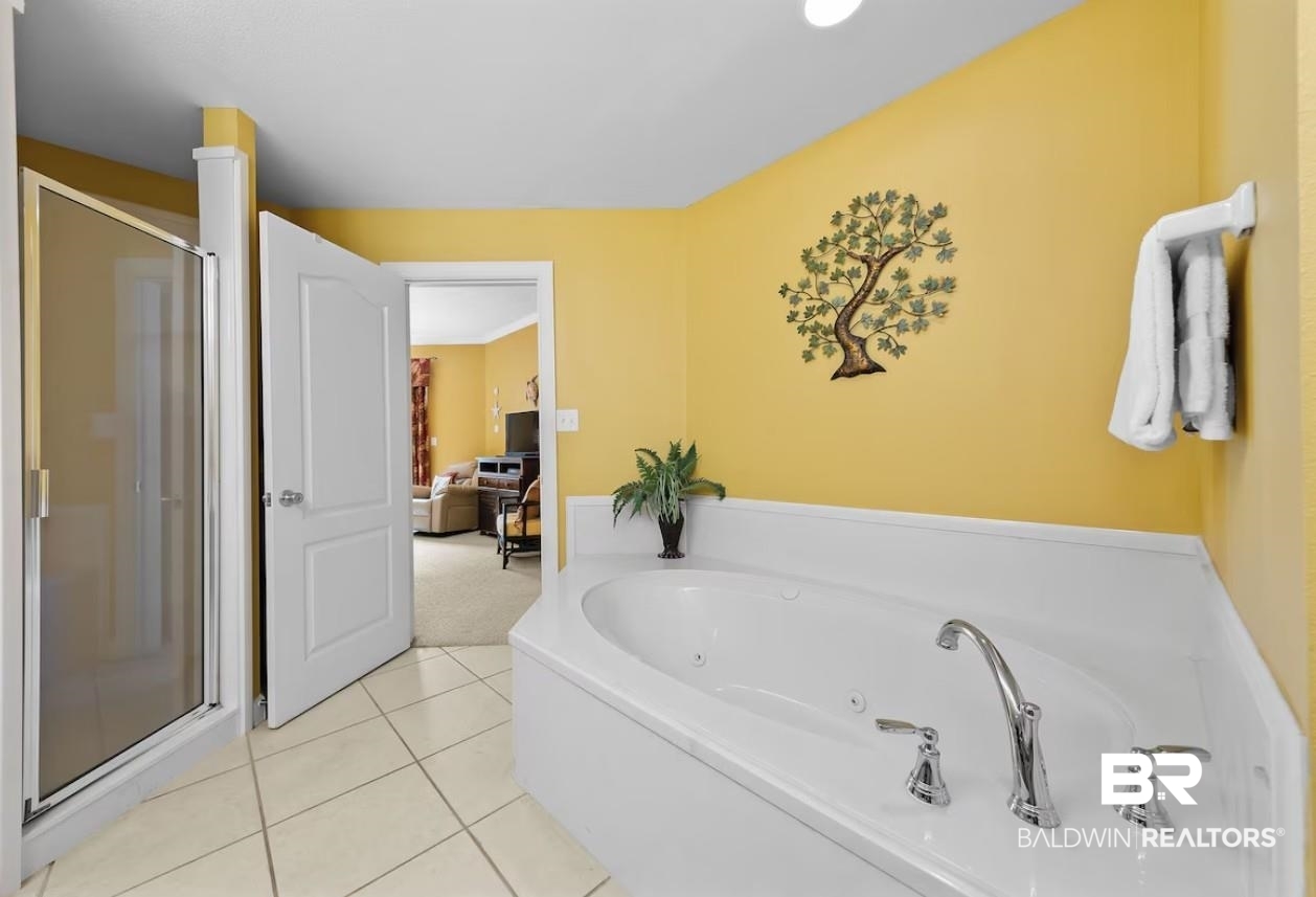 27770 Canal Road, Unit 2502 Orange Beach, AL 36561 - Photo 19 of 55 Bathroom featuring a stall shower, a jetted tub, light tile patterned flooring, and light carpet