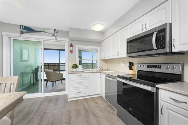 a kitchen with white cabinets and stainless steel appliances