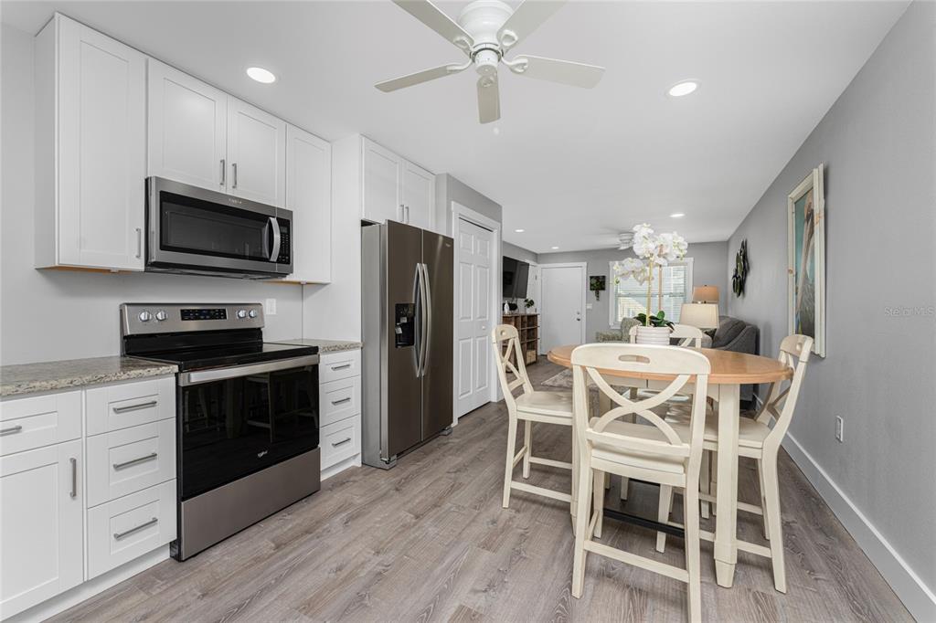5041 North Beach Road, Unit 4A AND 4B Englewood, FL 34223 - Photo 60 of 75 a kitchen with stainless steel appliances kitchen island granite countertop a refrigerator a stove a microwave oven a sink with island and chairs with wooden floor