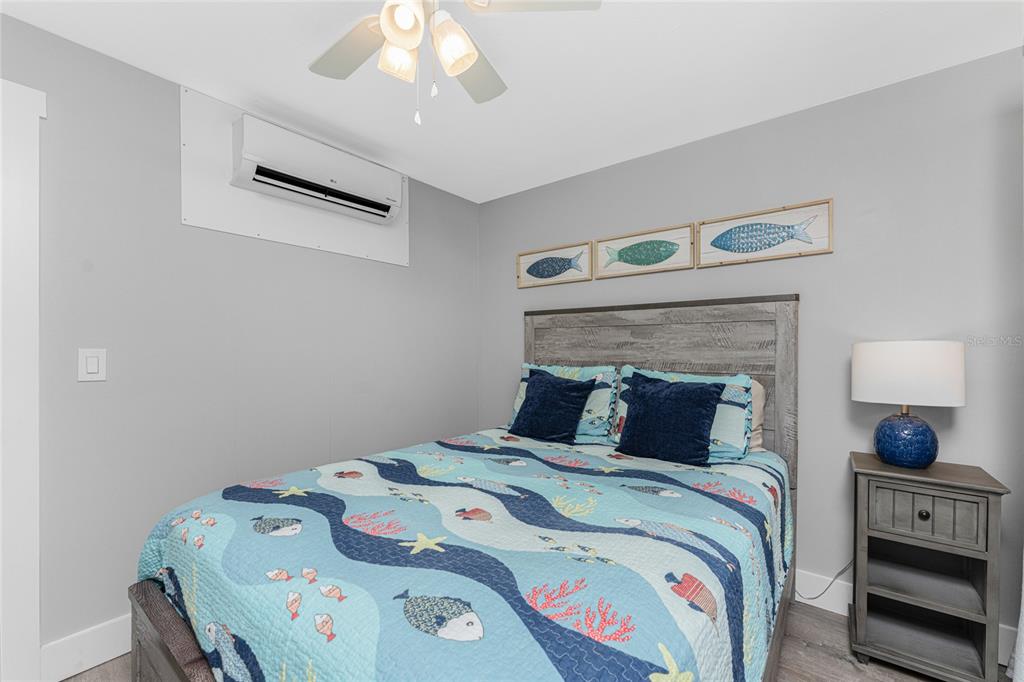 5041 North Beach Road, Unit 4A AND 4B Englewood, FL 34223 - Photo 68 of 75 a bedroom with a bed a window and a chandelier
