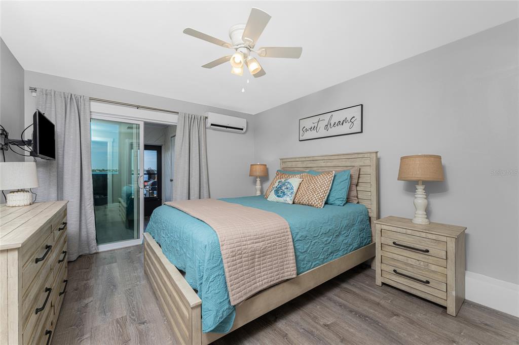 5041 North Beach Road, Unit 4A AND 4B Englewood, FL 34223 - Photo 72 of 75 a bedroom with a bed and a chandelier