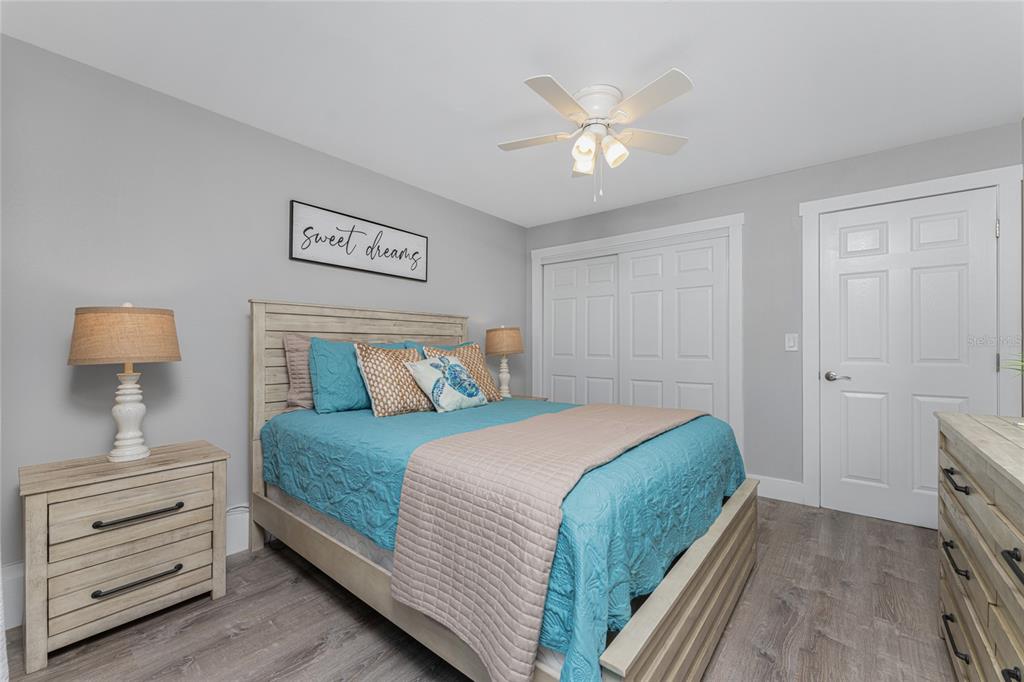 5041 North Beach Road, Unit 4A AND 4B Englewood, FL 34223 - Photo 73 of 75 a bedroom with a bed and a lamp on dresser