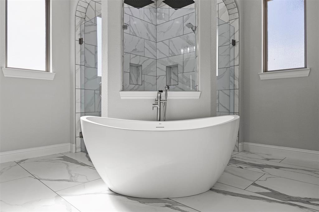 6381 Rigel Road Godley, TX 76044 - Photo 28 of 40 a white tub sitting next to a bathroom sink
