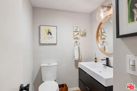 a bathroom with a toilet a sink and mirror