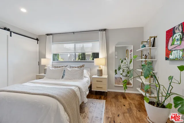 a bedroom with a bed and a potted plant