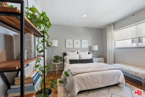 a bedroom with a large bed and a potted plant
