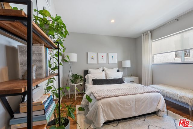 a bedroom with a large bed and a potted plant