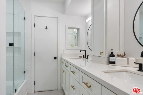 a bathroom with double vanity sink and a mirror