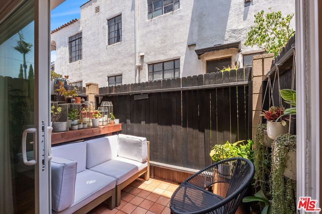 a view of a balcony with chairs and a potted plant