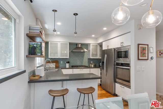 a kitchen with stainless steel appliances granite countertop a sink refrigerator and microwave