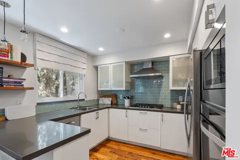 a kitchen with stainless steel appliances granite countertop a refrigerator and a stove