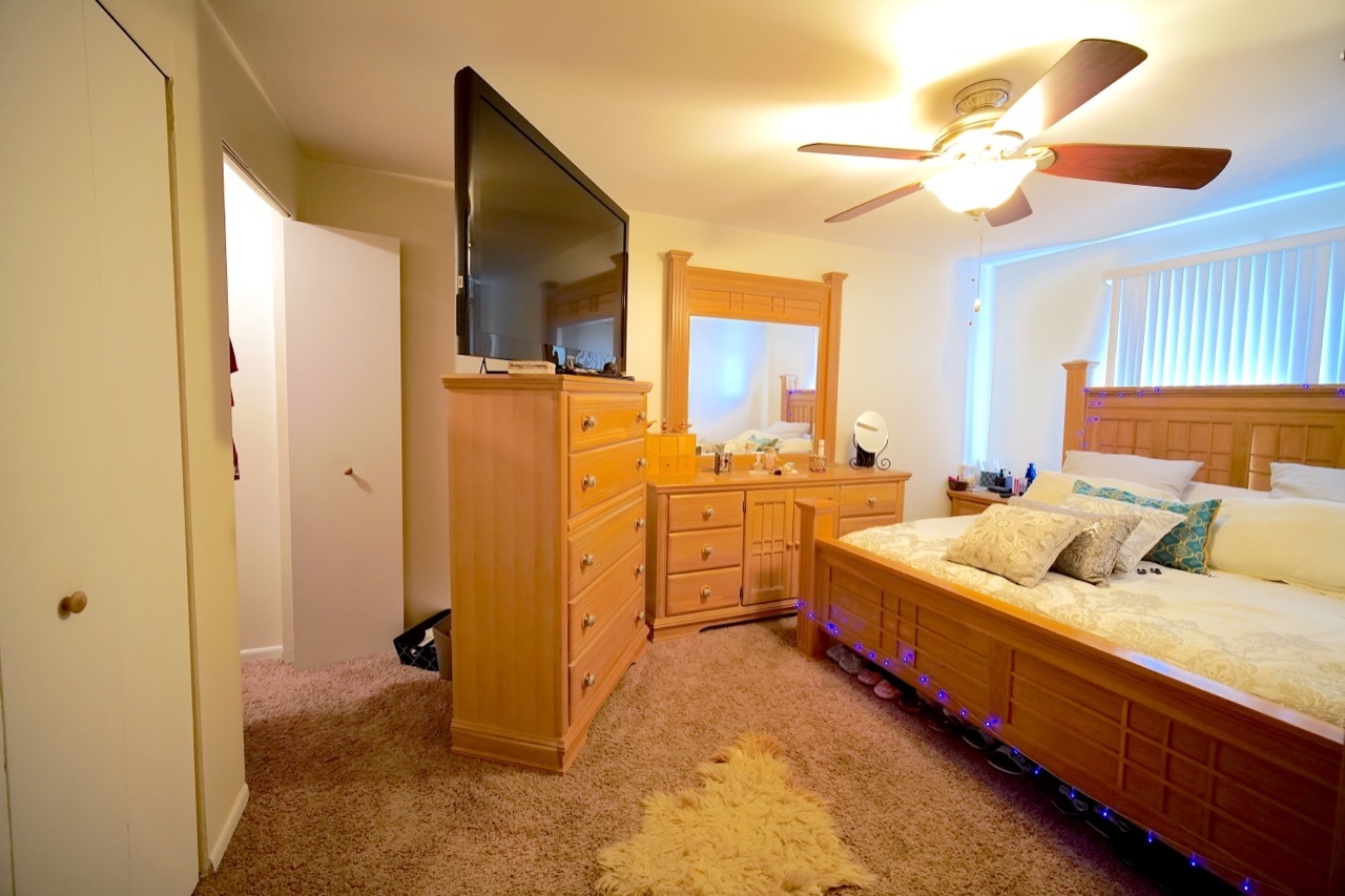9835 South Harlem Avenue, Unit S Chicago Ridge, IL 60415 - Photo 12 of 17 a bed room with a bed and a chandelier