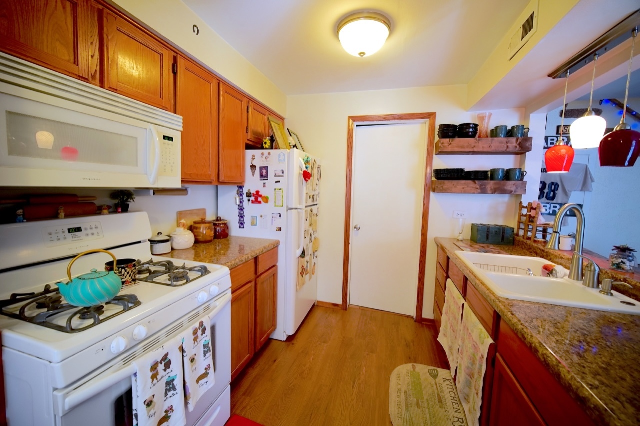 9835 South Harlem Avenue, Unit S Chicago Ridge, IL 60415 - Photo 4 of 17 a kitchen with stainless steel appliances granite countertop a sink stove and refrigerator
