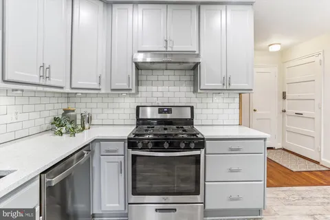 a kitchen with granite countertop white cabinets and appliances