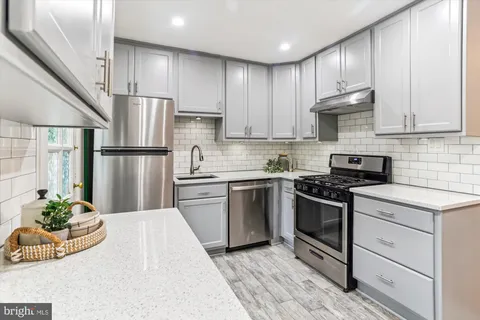 a kitchen with kitchen island granite countertop a sink stainless steel appliances and cabinets