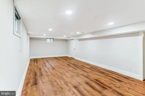 an empty room with wooden floor and natural light