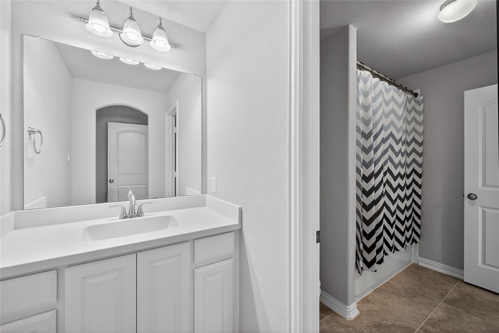 1039 Stephen Street Allen, TX 75013 - Photo 34 of 40 Bathroom featuring vanity and shower / tub combo with curtain