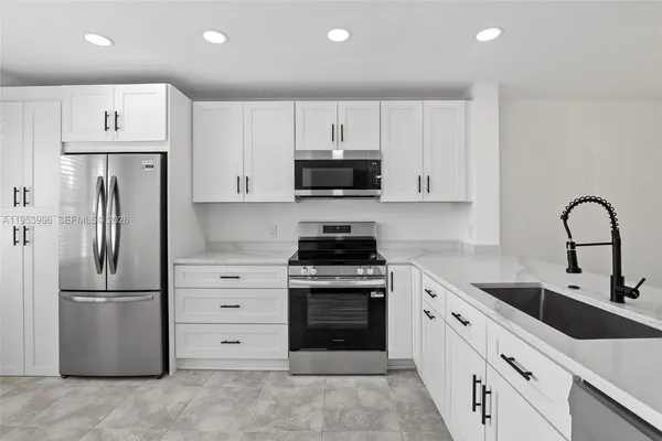 a kitchen with a refrigerator sink and cabinets