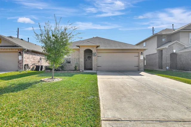 a front view of a house with a yard and garage
