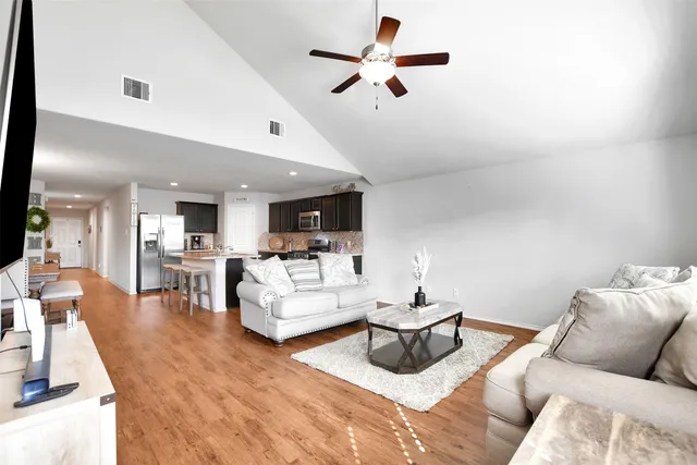 a living room with furniture and a wooden floor