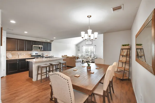 a view of a dining room with furniture a chandelier and wooden floor