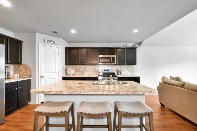 a kitchen with granite countertop kitchen island cabinets and refrigerator